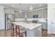Bright kitchen features gray cabinets, a large island with seating, quartz countertops, and stainless steel appliances at 175 Darby Meadow Ln, Ridgeville, SC 29472