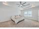 Bright main bedroom featuring a tray ceiling, neutral carpet, and a comfortable bed with a view of the backyard at 175 Darby Meadow Ln, Ridgeville, SC 29472