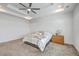 Bright main bedroom featuring a tray ceiling, neutral carpet, and a comfortable bed with a wooden dresser at 175 Darby Meadow Ln, Ridgeville, SC 29472