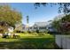 Expansive backyard with lush lawn, a white picket fence, and mature trees offering a serene and private setting at 1808 Ion Ave, Sullivans Island, SC 29482