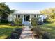 Charming home with a white metal roof, blue shutters, and a beautifully landscaped front yard at 1808 Ion Ave, Sullivans Island, SC 29482