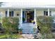 Charming cottage-style home featuring a welcoming front porch, classic white pillars, and a quaint blue bicycle at 1808 Ion Ave, Sullivans Island, SC 29482