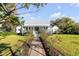 Charming home featuring a metal roof, blue shutters, inviting front porch, and a picturesque garden walkway at 1808 Ion Ave, Sullivans Island, SC 29482