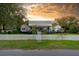 Charming home with a white picket fence and a welcoming facade, set against a beautiful sunset sky at 1808 Ion Ave, Sullivans Island, SC 29482
