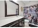 Stylish bathroom with dark vanity, a large framed mirror, and floral patterned shower curtain at 182 Callibluff Dr, Summerville, SC 29486