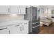 Modern kitchen showcasing stainless steel refrigerator, white cabinets, and tile backsplash at 182 Callibluff Dr, Summerville, SC 29486
