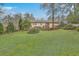 Expansive backyard featuring lush green lawn, mature trees, and a wooden deck for outdoor entertaining at 202 Crestwood Dr, Summerville, SC 29483