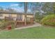 Backyard view with grassy yard, gravel pathway, deck and mature trees at 202 Crestwood Dr, Summerville, SC 29483