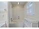 Bright bathroom featuring a bathtub and shower with a shuttered window and storage for an efficient use of space at 202 Crestwood Dr, Summerville, SC 29483
