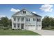 Two-story home with light blue siding and a two-car garage, and columns on the front porch at 2022 Riverbend Dr, Charleston, SC 29412