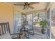 Screened patio with a ceiling fan, rocking chairs, and potted plant creates an inviting outdoor relaxation space at 205 Yellow Hawthorn Cir, Summerville, SC 29483
