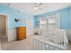 Light and airy Bedroom with calming blue walls, a plush chair, and a white crib near the window at 207 Billinger St, Summerville, SC 29486