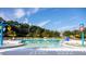 Large community pool area with sun loungers, umbrellas, play structures, and mature landscaping at 207 Billinger St, Summerville, SC 29486