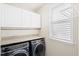 Well-lit laundry room with modern washer and dryer, countertop, and cabinet storage space at 207 Billinger St, Summerville, SC 29486