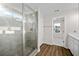 Bright bathroom featuring a tiled walk-in shower with glass surround and vinyl floors at 2150 Pimlico Dr, Ridgeville, SC 29472