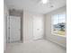 This bedroom features neutral walls, carpeted floors, a ceiling fan, and a window overlooking a neighborhood at 2150 Pimlico Dr, Ridgeville, SC 29472
