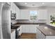 Bright kitchen with white cabinetry, stainless steel appliances, and a view from the window overlooking the backyard at 2150 Pimlico Dr, Ridgeville, SC 29472