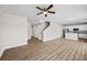 Open concept living space with hardwood flooring, bright lighting, and a view of the kitchen and staircase at 2150 Pimlico Dr, Ridgeville, SC 29472