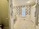 Bright bathroom featuring decorative wallpaper, wainscoting, a shower, and modern fixtures at 2164 Highway 78, Dorchester, SC 29437