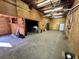 The interior of the garage shows the open layout with wood walls, a cement floor, lighting and two Personal doors at 2164 Highway 78, Dorchester, SC 29437
