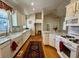 Open kitchen with white cabinets, marble countertops, hardwood floors, and stainless steel appliances at 2164 Highway 78, Dorchester, SC 29437