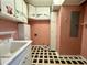 Quaint laundry room with pink walls, patterned floors, and vintage-style cabinets at 2164 Highway 78, Dorchester, SC 29437