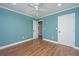 A bedroom with beautiful blue walls and hardwood floors with an open door to another room or closet at 2306 Chairmaker Ct, Charleston, SC 29414