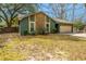 Charming home featuring green siding, stone accents, well-maintained landscaping, and an attached garage at 2306 Chairmaker Ct, Charleston, SC 29414