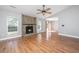 Bright living room with hardwood floors, a cozy stone fireplace, and a ceiling fan at 2306 Chairmaker Ct, Charleston, SC 29414