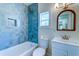 Charming bathroom features blue tiled shower and a vanity with a rope-trimmed mirror at 2314 Kent Ave, North Charleston, SC 29405