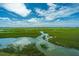 Scenic marsh view showcasing the tranquility of nature and the beauty of coastal wetlands with waterways at 242 Little Oak Dr, Folly Beach, SC 29439