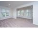 Bright living room with neutral carpet and a view of mature foliage outside multiple windows at 2522 Egret Crest Ln, Charleston, SC 29414