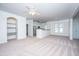 Cozy living room with neutral carpet, ceiling fan, and built-in shelves near kitchen at 2522 Egret Crest Ln, Charleston, SC 29414