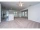 Spacious living room with neutral carpet and partial view of kitchen and appliances at 2522 Egret Crest Ln, Charleston, SC 29414