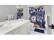 Bright bathroom featuring a double vanity, white cabinets, and a patterned shower curtain at 2707 Waterpointe Cir, Mount Pleasant, SC 29466