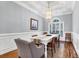 Elegant dining room featuring wainscoting, stylish lighting, and a large window at 2707 Waterpointe Cir, Mount Pleasant, SC 29466