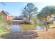 Picturesque view of a tranquil pond reflecting nearby homes and mature trees at 2707 Waterpointe Cir, Mount Pleasant, SC 29466