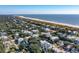 Expansive aerial view of a coastal town, highlighting the beachfront properties and sprawling tree coverage at 3006 Cameron Blvd, Isle of Palms, SC 29451
