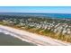 A picturesque aerial view of coastal homes with direct beach access, nestled among lush greenery along the beautiful shoreline at 3006 Cameron Blvd, Isle of Palms, SC 29451