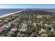 An aerial view showcases homes nestled among trees with a beach on one side and a bay and waterway on the other at 3006 Cameron Blvd, Isle of Palms, SC 29451
