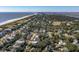 High-angle aerial of a beachfront community with houses nestled among lush greenery, ocean in the distance at 3006 Cameron Blvd, Isle of Palms, SC 29451