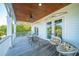 Covered balcony offers a relaxing space with seating and views of lush greenery beyond double doors at 3006 Cameron Blvd, Isle of Palms, SC 29451