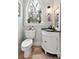 Charming powder room featuring a sleek black corner vanity and an arched window providing natural light at 3006 Cameron Blvd, Isle of Palms, SC 29451