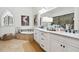 Elegant bathroom with double vanity, marble countertops, and a soaking tub by a unique window at 3006 Cameron Blvd, Isle of Palms, SC 29451