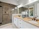 Bathroom featuring glass shower, double sinks, tan countertops, and white cabinets at 3006 Cameron Blvd, Isle of Palms, SC 29451