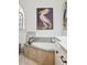 Corner soaking tub featuring a stone surround, bronze fixtures, and decorative artwork at 3006 Cameron Blvd, Isle of Palms, SC 29451