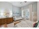 Light-filled bedroom with a ceiling fan, dresser, daybed, mirror and patterned comforter in a modern home at 3006 Cameron Blvd, Isle of Palms, SC 29451