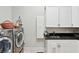 Well-lit laundry room with stainless steel washer and dryer, white cabinets, and sink at 3006 Cameron Blvd, Isle of Palms, SC 29451