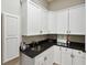 Laundry room featuring white cabinets, a black countertop, and a stainless steel sink at 3006 Cameron Blvd, Isle of Palms, SC 29451