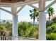 Relaxing porch view showcasing palm trees, lush greenery, and nearby houses at 3006 Cameron Blvd, Isle of Palms, SC 29451